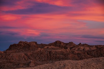 Fototapeta na wymiar Intense hues of sunset colour in the sky at Valle de la Luna, or Moon Valley, San Pedro de Atacama, northern Chile.
