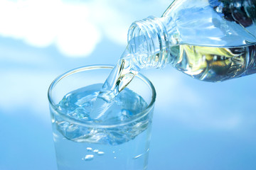 water in glass put on table under the blue sky reflection for healthy or drink, nature concept.