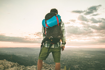 Mountaineer on top of a mountain with a backpack. Social network style photo