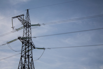 Photo of power transmission tower. High voltage pillar on blue sky background