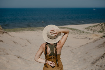 Fototapeta na wymiar Woman wearing a sunhat on the beach in summer