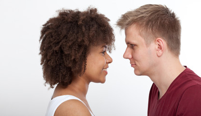 Happy Young couple of a mixed race looking at each other.