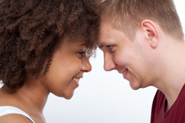 Happy Young couple of a mixed race looking at each other.