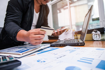 A businessman using mobile smart phone and holding credit card for shopping online. Business concept.