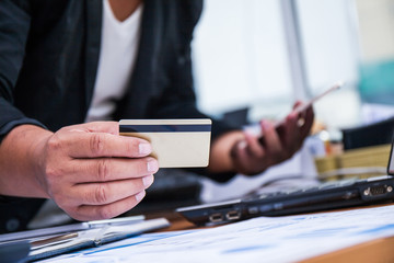 Fototapeta premium A businessman using mobile smart phone and holding credit card for shopping online. Business concept.