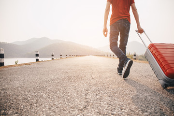 Travel concept. Men wear sneakers shoes and travel with luggage on the street.