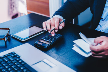 A businessman analyzing investment charts with using calculator for calculate profit and loss his...