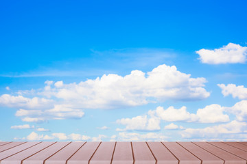 Empty wood table top on blurred blue sky background.