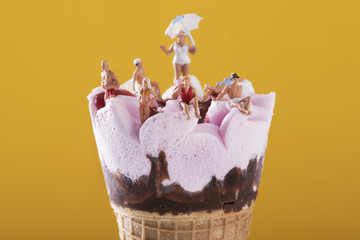 miniature people in swimsuit on an ice cream.