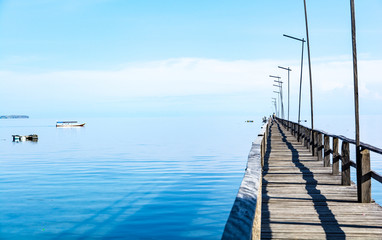 Obraz premium A Long Wooden Pier on Clear Turquoise Water with Endless Sea in Flores Island, Labuan Bajo, Indonesia