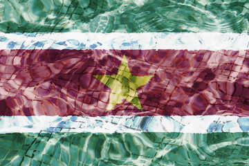 Texture of Suriname flag in the pool, water. Circles on the water.