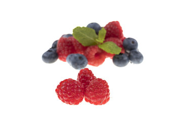 Himbeeren und Minzblatt mit unscharfe beeren im Hintergrund