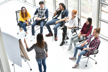 Young Asian businesswoman giving presentation on future plans to his colleagues at office