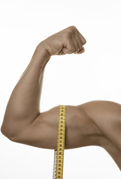 Angespannter Frauenbizeps mit Ma&szlig;band 