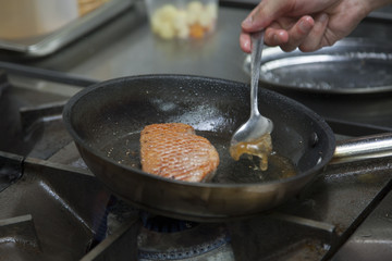 The cook fry the duck fillet in a frying pan. Gas hob