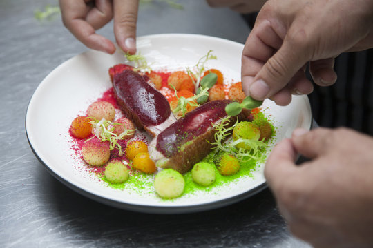 The cook prepares a dish of duck fillet