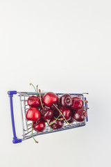 Ripe cherries in a shopping cart isolated