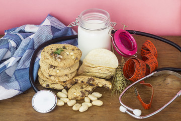 homemade white and black chocolate cookies on wood table with chips,milk and peanuts and weight loss concept