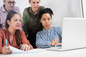 Fototapeta premium Business team looking at a laptop and gesturing