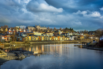 Fototapeta premium A view of Trondheim reflected in the river. Sunset before the storm. Norway