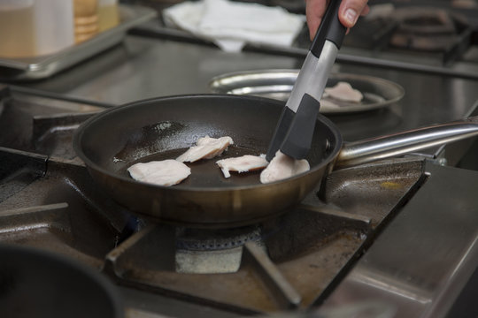 Hands cook, fry in a frying pan chicken