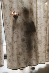 Child playing behind a curtain.