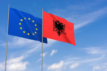 European Union and Albania flags over blue sky background.