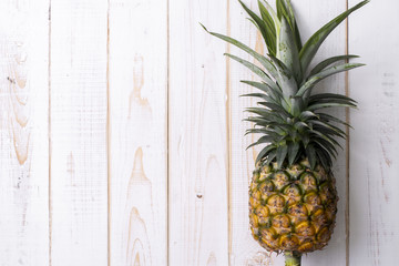 Pineapple on white wooden background