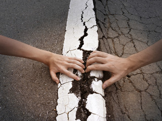 Fighting couple hands pull apart land and white line on asphalt road arguments relationships...