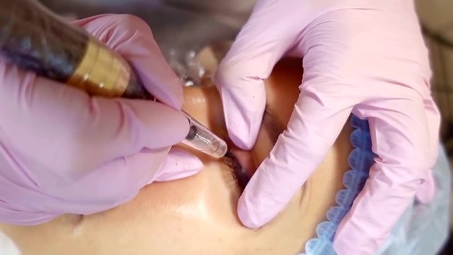 Cosmetologist making eyeliner permanent make up