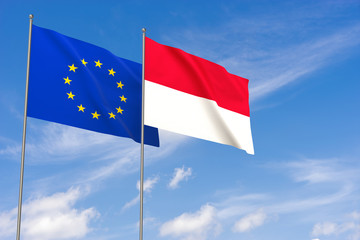European Union and Monaco flags over blue sky background.