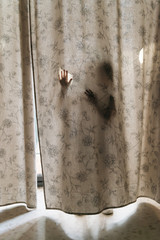 Child playing behind a curtain.