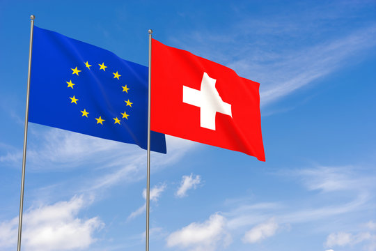 European Union and Switzerland flags over blue sky background.
