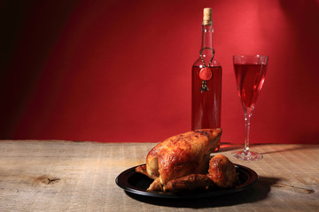 Kurczak pieczony z rożna i lampka czerwonego wina. - obrazy, fototapety, plakaty