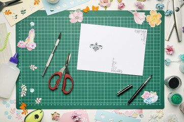 Homemade greeting card and tools on the cutting Mat. Scrapbooking, top view