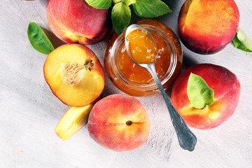 Peach vanilla jam with fresh peaches on table.