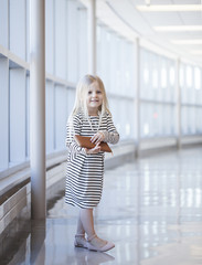 Obraz premium Portrait of happy little girl wearing striped dress with wallet
