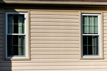 Closeup of two windows, wall, exterior of townhouse, townhome with sunlight, light, sunny day