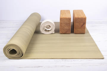 Composition of yoga, meditation or pilates accessories on white wooden background. 