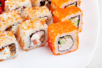 Sushi on a light background, close-up. With caviar of flying fish. Fresh colored sushi.