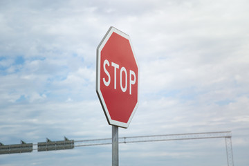 A red stop sign on blue sky with cloudscape background