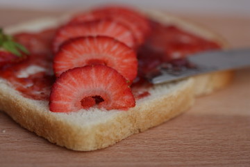 Bread slice with jam and strawberries.