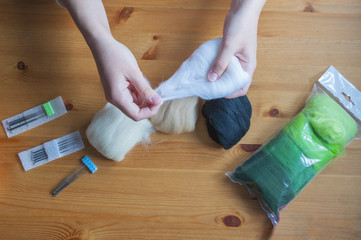 Girls hands stretching wool for felting