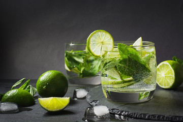 Mojito cocktail in glass on black table. Close up.