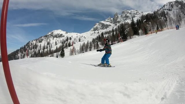 Freestyle skiing. Little boy jumping in a snowpark. A 5 year old child enjoys a winter holiday in the Alpine resort. Stabilized shot. Slow motion.