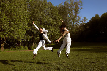 two young girl jump in park