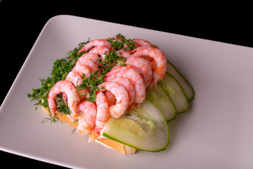 Shrimp sandwich on a plate with lights in the background