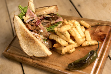 Sandwich con papas en mesa de madera