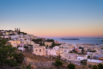 Obraz premium Panoramic view of Ermoupoli city of Syros Island in Cyclades, Greece. View of the houses, the port and the Orthodox Anastaseos church on sunset 