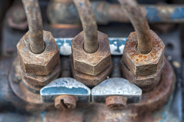 Macro shot of an old tractor's engine. Selective focus on the three nuts
